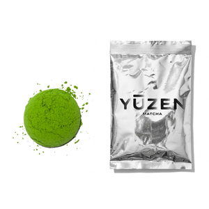 Daichi ceremonial matcha sample in a silver foil sachet beside a pressed disc of green powder