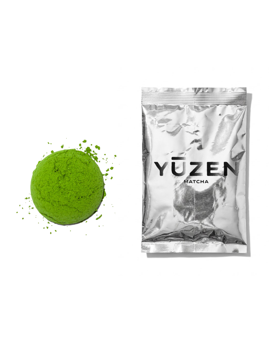 Daichi ceremonial matcha sample in a silver foil sachet beside a pressed disc of green powder