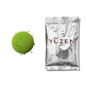 Sakura ceremonial matcha sample in a silver foil sachet beside a pressed disc of powder